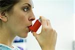 Femme utilisant l'asthme inhalateur