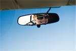 Woman's face reflected in rearview mirror