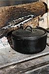 Cast iron pot sitting beside fireplace