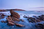 Lune montante ci-dessus les côtes rocheuses de la baie de Wembury au crépuscule, Devon, Angleterre, Royaume-Uni, Europe