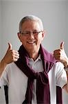 mature man with grey hair holding thumbs up and smiling