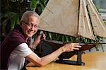 homme plus âgé avec bateau à voile modèle