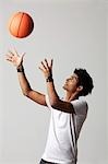 young man throwing basketball into the air