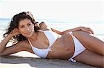 Portrait of Young Woman Lying on Beach, Zuma Beach, California, USA