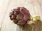 Single Purple Artichoke on Wood