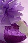 A chocolate Easter egg in purple foil with purple bow