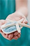 Young woman holding bath salts with starfish