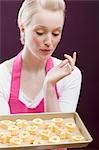 Young woman with a baking tray of freshly-baked biscuits