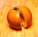 An orange pumpkin with a piece removed