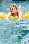 Blond woman with air bed in water