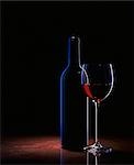 A glass of red wine and a wine bottle