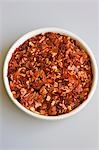 Dried chilli flakes in small white bowl