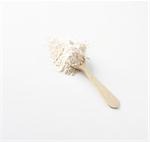 Wholemeal wheat flour with a wooden spoon