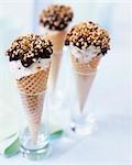 Three cones of stracciatella ice cream with chocolate & nuts