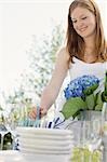 Woman decorating table in garden for a summer party