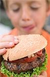 Small boy holding hamburger
