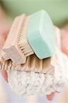 Woman holding soap, soap dish, brush and towel