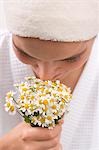 Woman smelling chamomile flowers