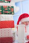 Un tas de cadeaux de Noël, enfant en chapeau de père Noël