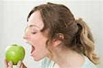 Woman biting into green apple