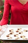 Woman holding baking tray of checkerboard cookies