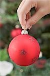 Hand holding red Christmas bauble