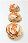 Trois blinis avec crème sure et caviar