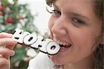 Woman biting Christmas biscuit (the word HOHO)