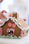 Child decorating gingerbread house