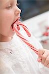 Small girl sucking candy cane