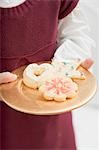 Small girl holding plate of biscuits