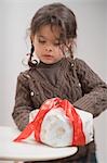 Small girl with cake in Christmas wrapping paper