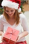 Femme au chapeau de père Noël cadeau de Noël en regardant