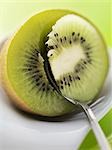 Spooning the flesh out of a kiwi fruit