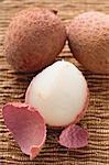 Three lychees, one half-peeled