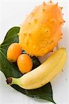 Banane, kiwano et kumquats sur feuille