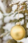 Christmas bauble on snow-covered fir branch out of doors