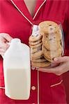 Woman holding glass full of cranberry cookies & bottle of milk