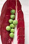 Several peas on radicchio leaf