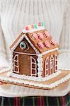 Woman holding gingerbread house