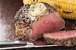 Peppered steak with herb butter and corn on the cob