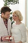 Couple avec les cadeaux de Noël sous le gui