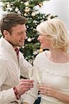 Man & woman clinking glasses of sparkling wine (Christmas)