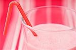 Lait aux fraises en verre avec de la paille (gros plan)