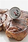 Grilled T-bone steak with meat thermometer