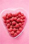 Raspberries in heart-shaped plastic container from above