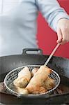 Deep-frying spring rolls in wok