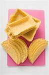 Assorted taco shells on pink chopping board