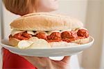 Woman serving a meatball sandwich