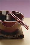 Lacquer bowl with chopsticks on brown cloth (Asia)